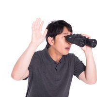 双眼鏡で覗き込む男性の監視・調査の写真