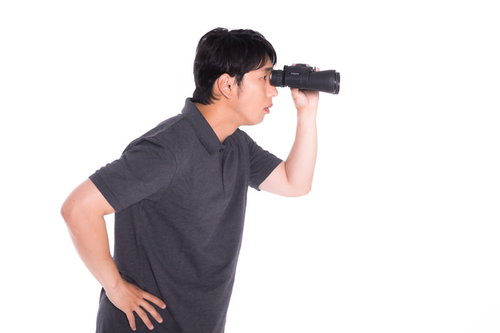 双眼鏡で観察する笑顔の男性