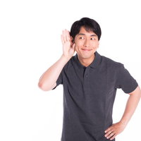 自分の良い噂ににんまりして聞き耳を立てる男性の写真