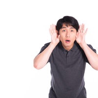 口元に手を当てて考え込む男性の写真
