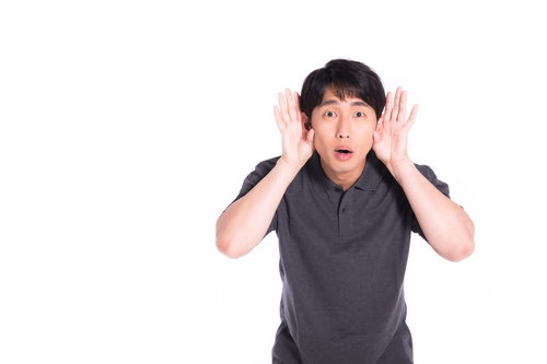 口元に手を当てて考え込む男性