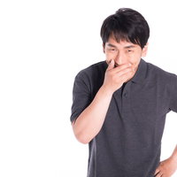 ほくそ笑む男性がニヤニヤと計画通りに事を進めるの写真