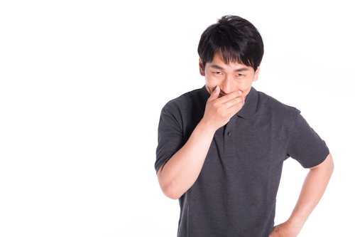 論破して勝利を確信したクレーマーの男性がニヤニヤ笑う