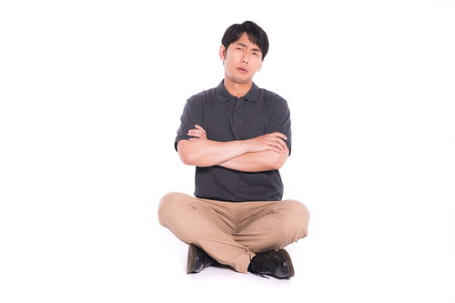 腕を組んで床に座り込み主張を繰り返すプロ市民の男性