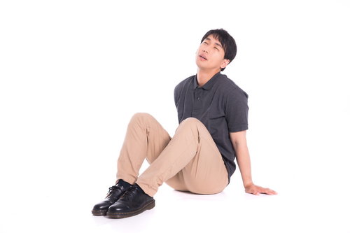 疲れて床に座り込む男性の休憩風景