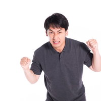 怒りに任せて暴力をふるいそうになるも我慢する男性の写真