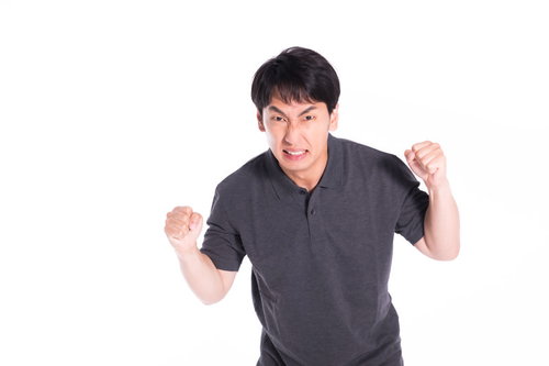 怒りに任せて暴力をふるいそうになるも我慢する男性