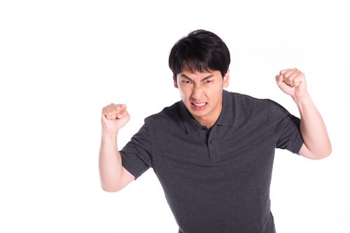 眉間にしわを寄せて怒るクレーマーの男性の怒りの表情