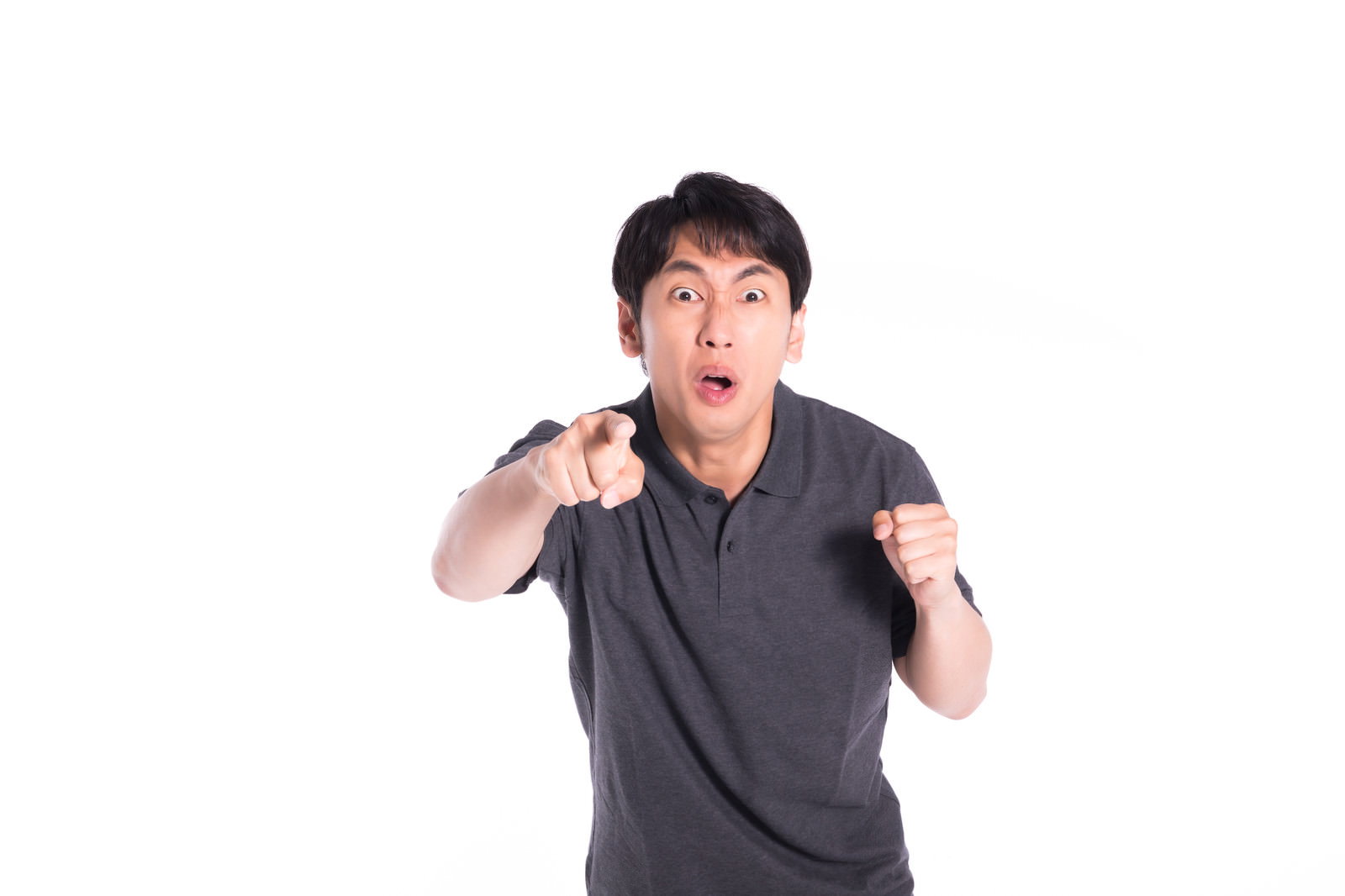 グレーのシャツを着た男性が指を突き出して怒っている表情［モデル：大川竜弥］