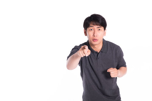 誇大広告だとイチャモンをつける男性が指をさして怒る