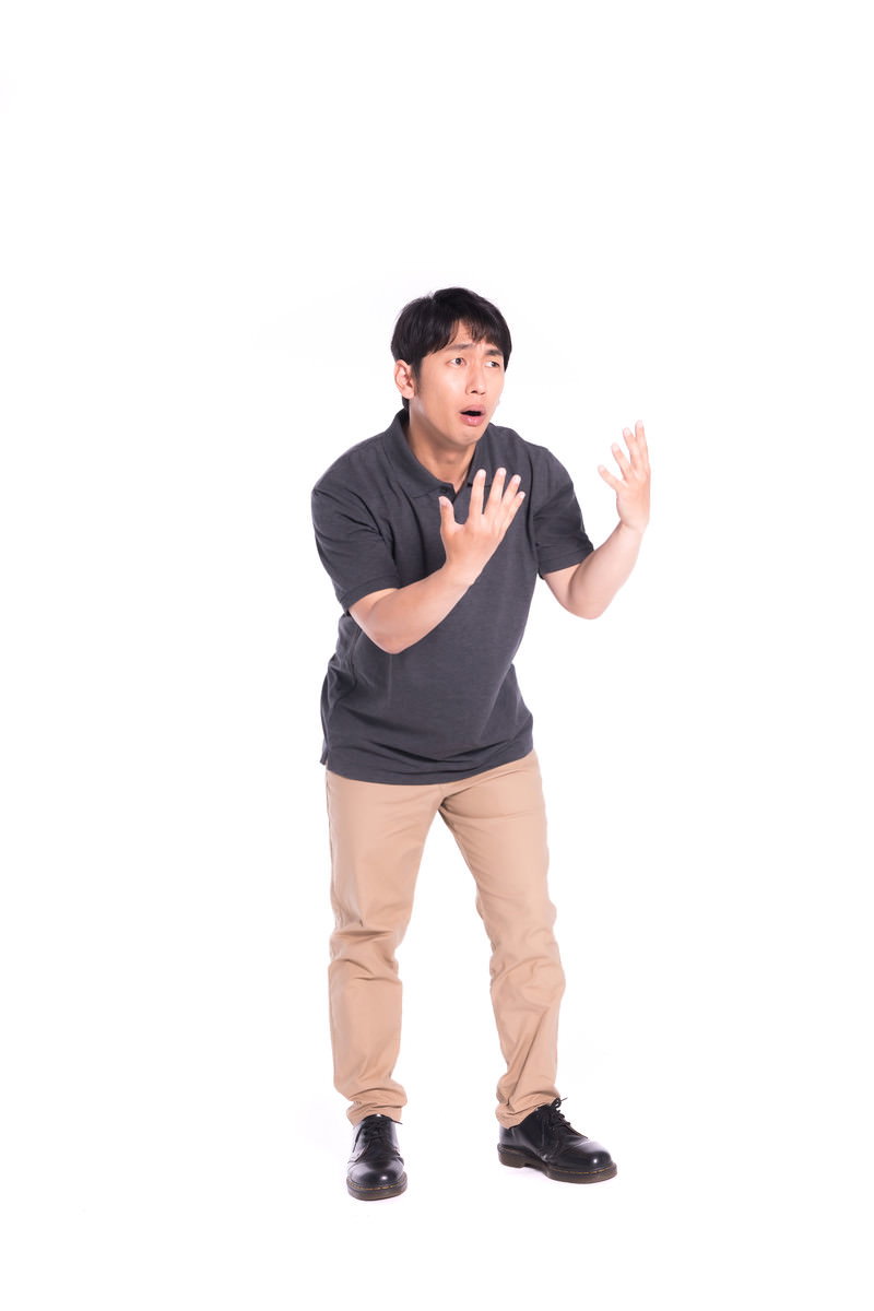 かかってこいやのポーズで片手を前に出している男性［モデル：大川竜弥］