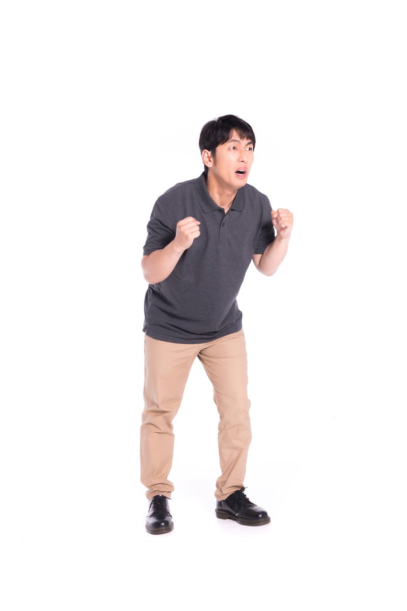 グレーのTシャツを着た男性が大声で叫んでいる［モデル：大川竜弥］