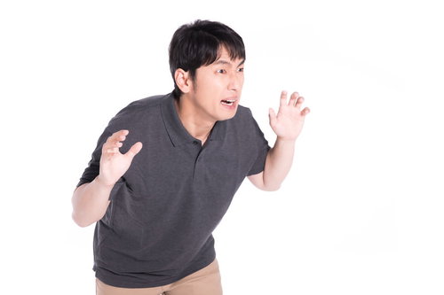 グレーのポロシャツを着た大きな声で威嚇する男性