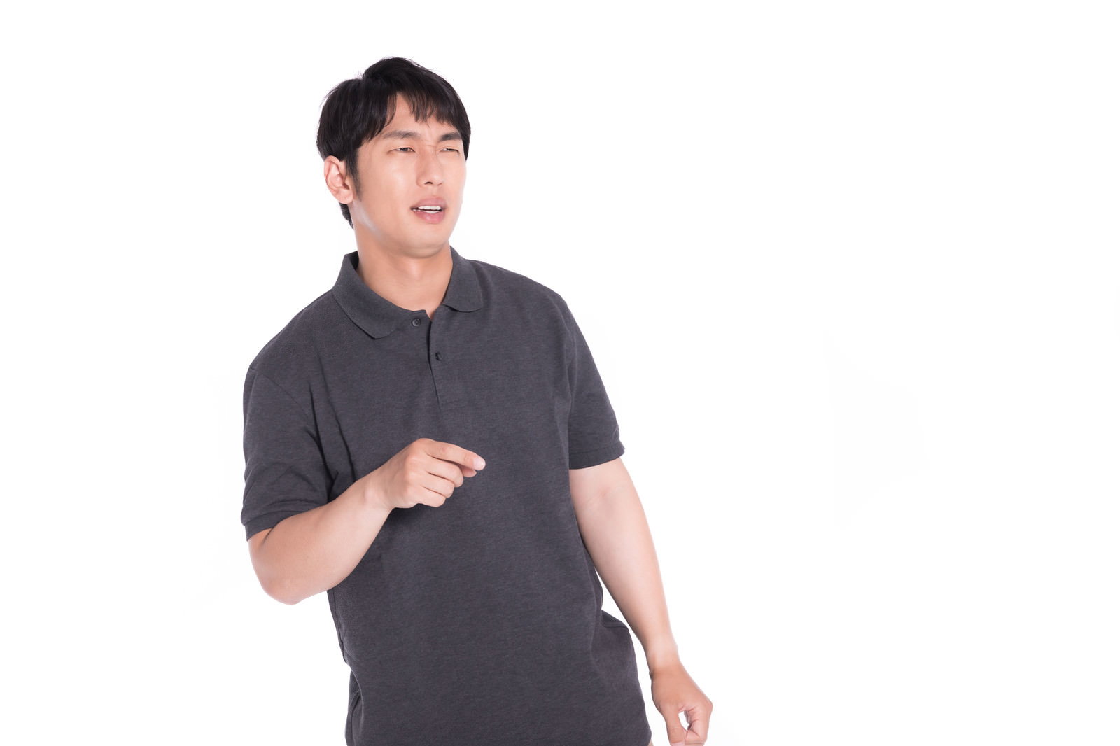 グレーのTシャツを着た男性が指を差している様子［モデル：大川竜弥］