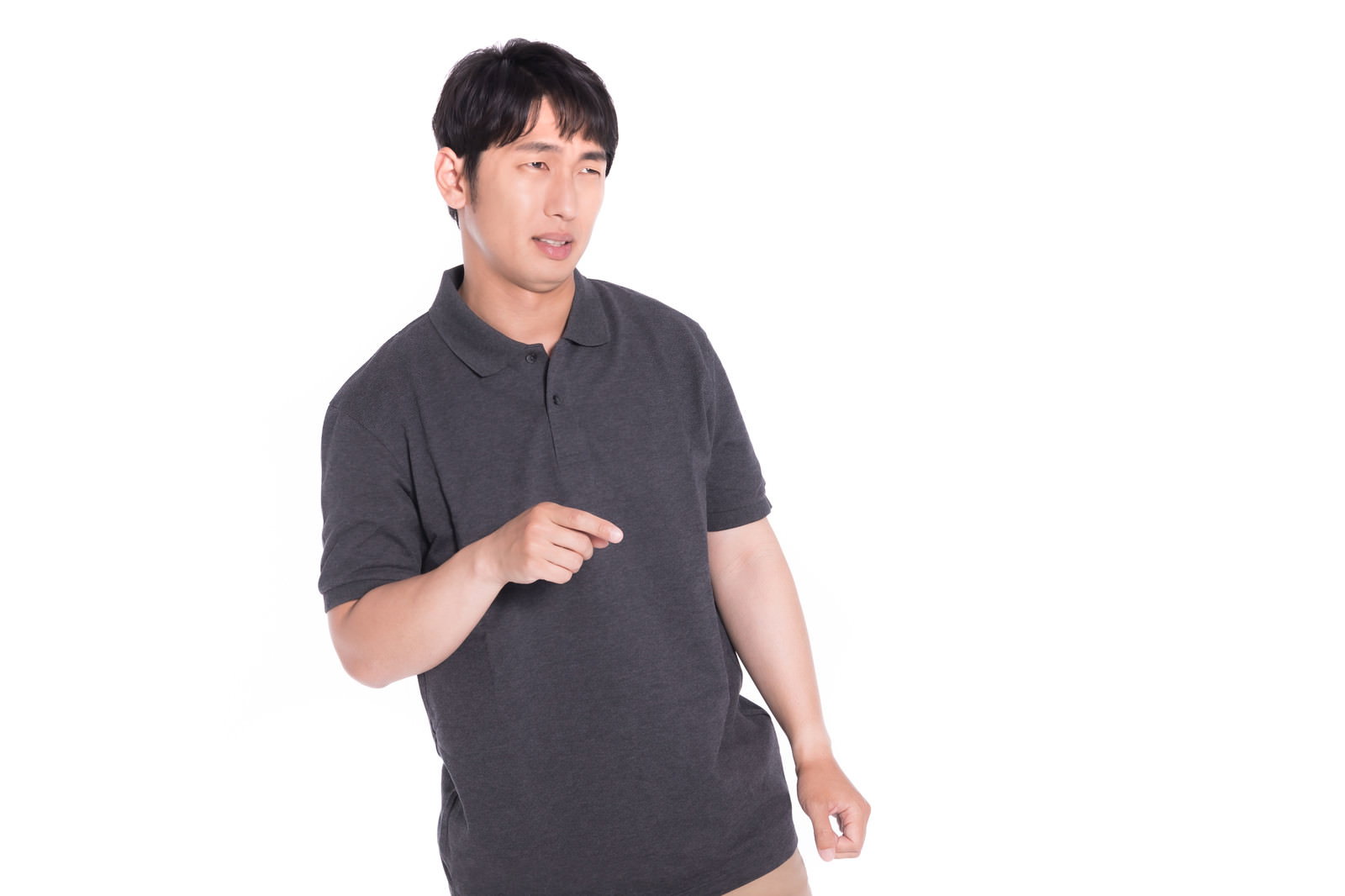 グレーのTシャツを着た男性が右手で指をさして不満を表現している［モデル：大川竜弥］
