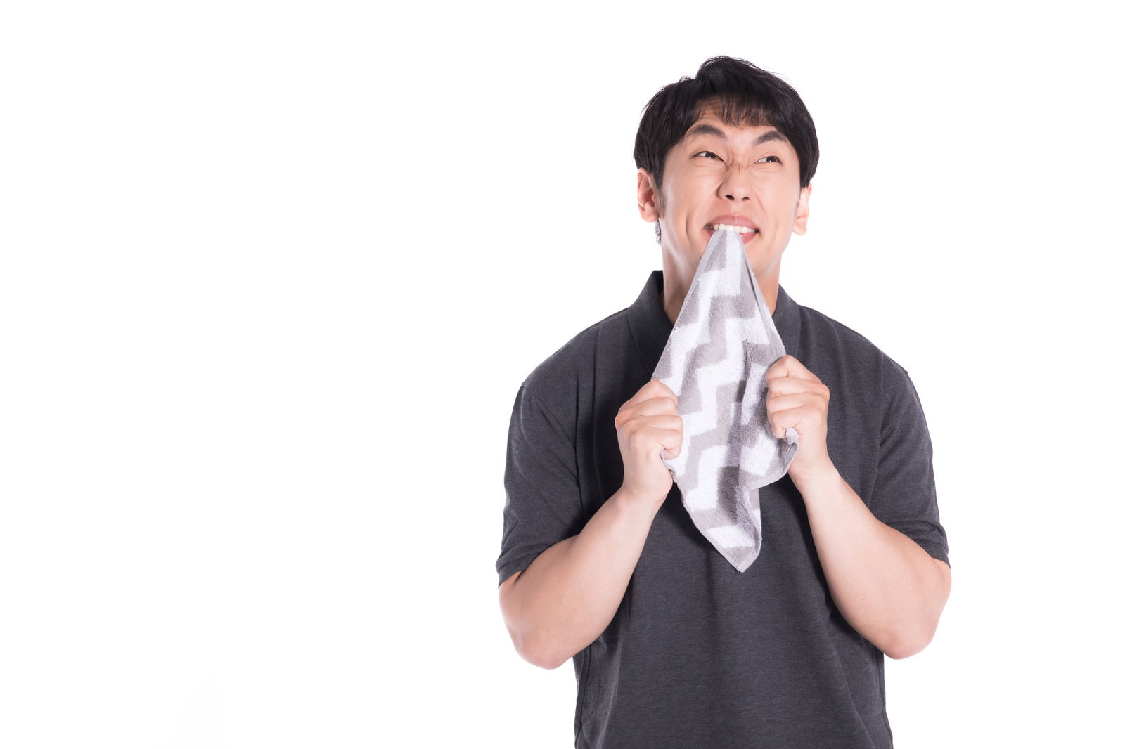 白いハンカチを噛みしめて悔しがる男性［モデル：大川竜弥］