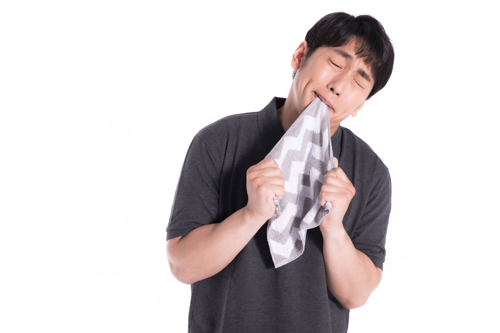 白いハンカチで涙を拭いている黒いTシャツを着た男性［モデル：大川竜弥］