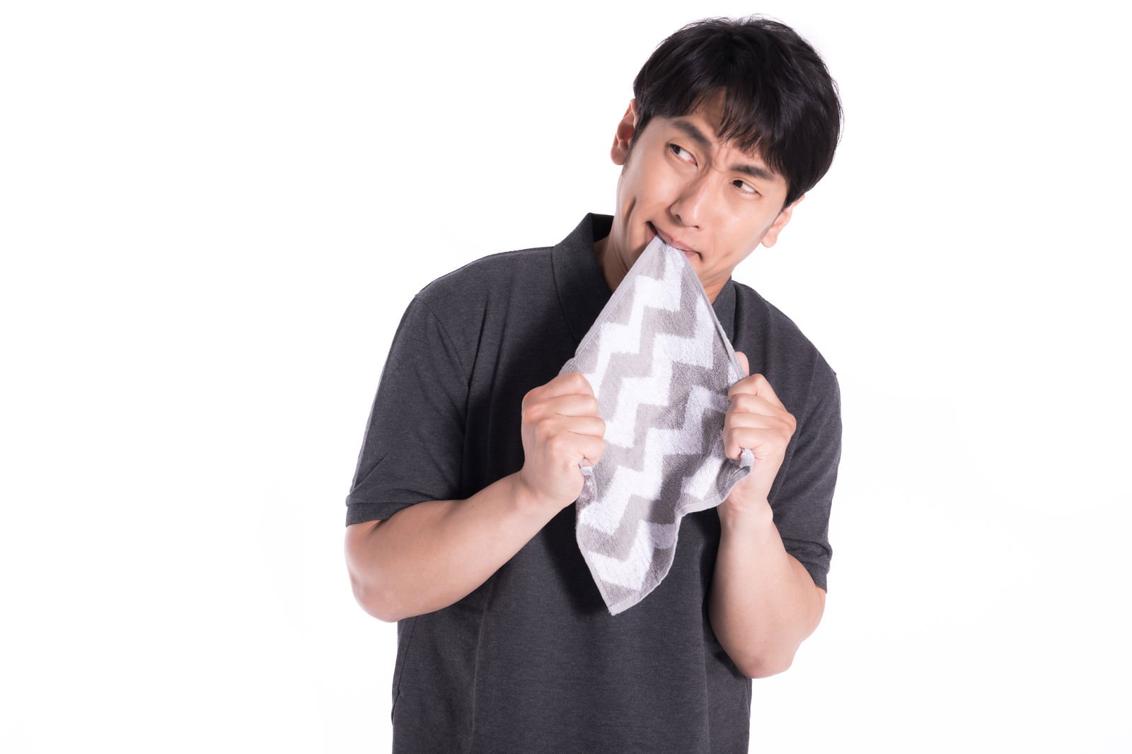 白いタオルで涙を拭きながら悲しそうに下を向く男性［モデル：大川竜弥］