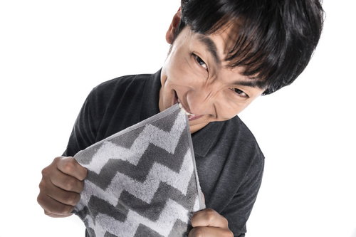 怒りが収まらない黒いスーツの男性クレーマー