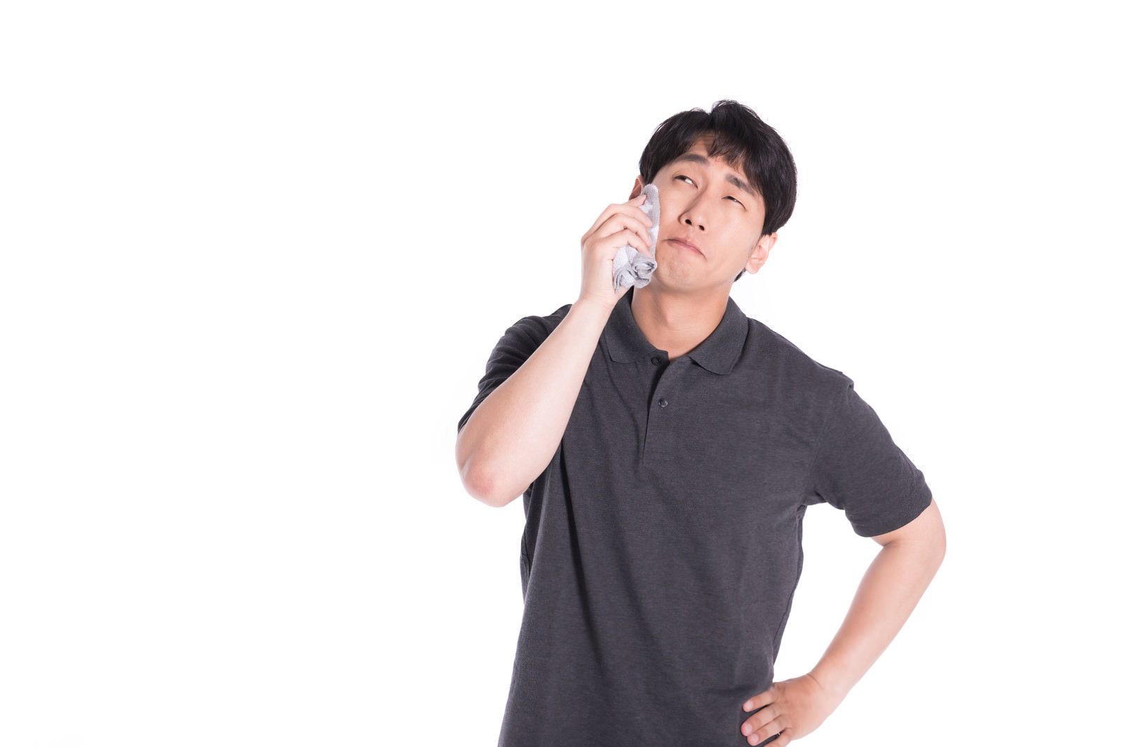 ハンカチで額の汗を拭いているグレーのTシャツの男性［モデル：大川竜弥］