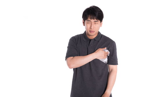 脇汗の汗染みをハンカチで隠す男性の多汗症対策