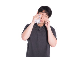 白いハンカチで涙を拭ううそ泣きをする男性の写真