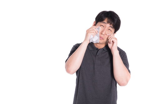 白いハンカチで涙を拭ううそ泣きをする男性