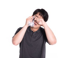 泣きながらハンカチで涙を拭う男性の悲しみと感情表現の写真