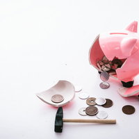 お金がない！割れたピンク貯金箱から散らばる硬貨の写真