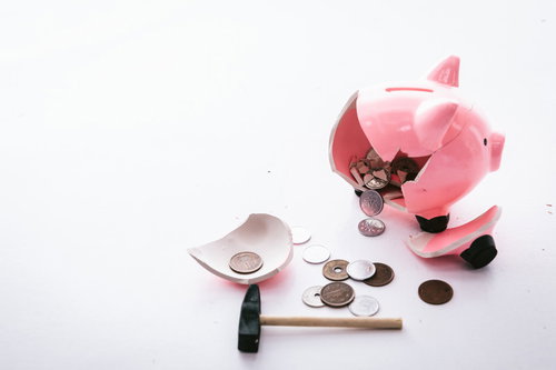 お金がない！割れたピンク貯金箱から散らばる硬貨