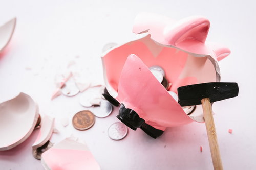 ハンマーで割ったピンク貯金箱から散らばる小銭