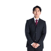 批判を受けて申し訳なさそうな表情の会社員男性の写真