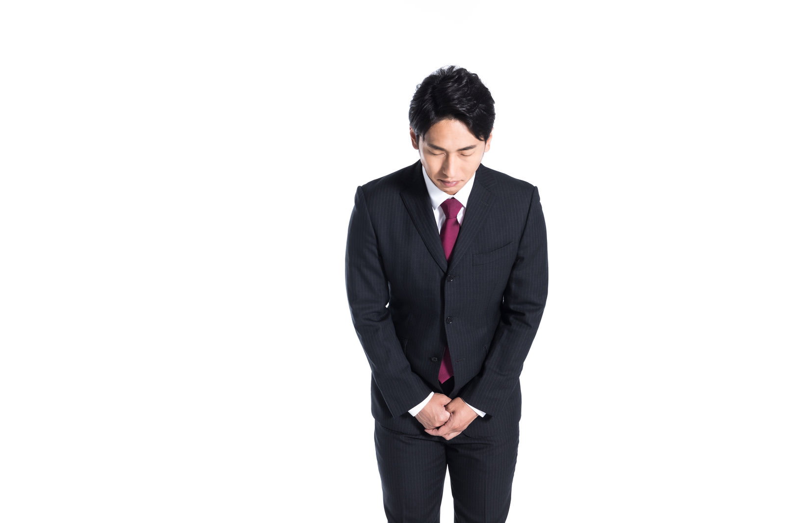 黒いスーツを着た男性が軽く会釈をしている［モデル：大川竜弥］