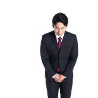 黒いスーツの男性が軽く会釈する部下のビジネスマナーの写真