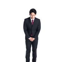 謹んでお詫び申し上げる会社員の深いお辞儀の写真