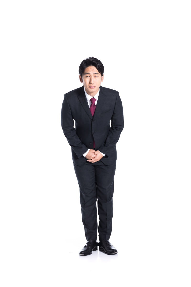 黒いスーツを着た男性が深くお辞儀をしている様子［モデル：大川竜弥］