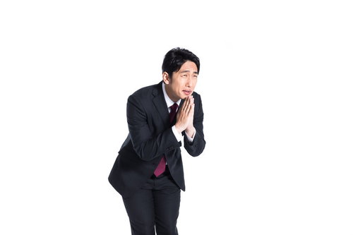 再度チャンスをください、と手を合わせて懇願するビジネスマン