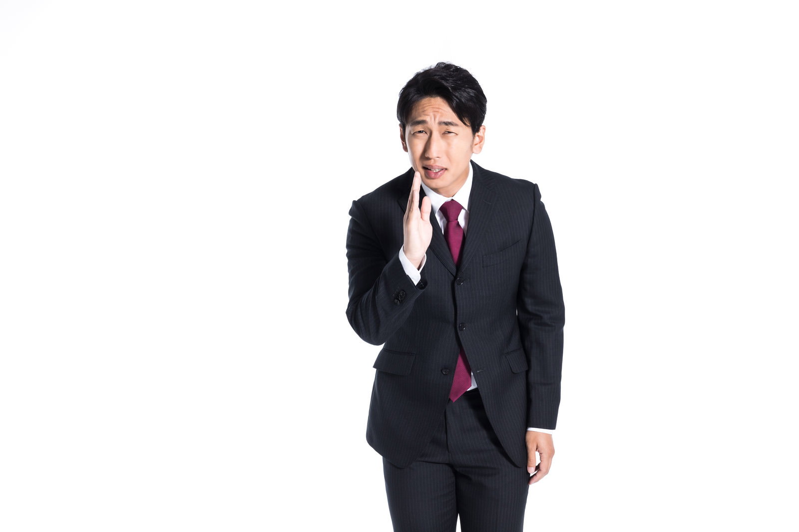 黒いスーツを着た男性が手を合わせて頭を下げている［モデル：大川竜弥］