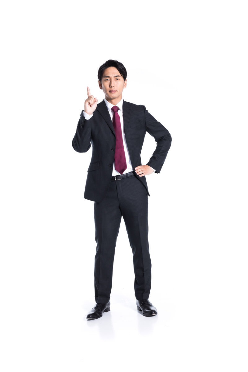 紺色スーツに紫ネクタイの男性が右手で指差しポーズ［モデル：大川竜弥］