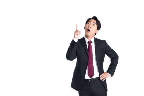 上部のバナーを指差して驚くスーツ姿のビジネスマン