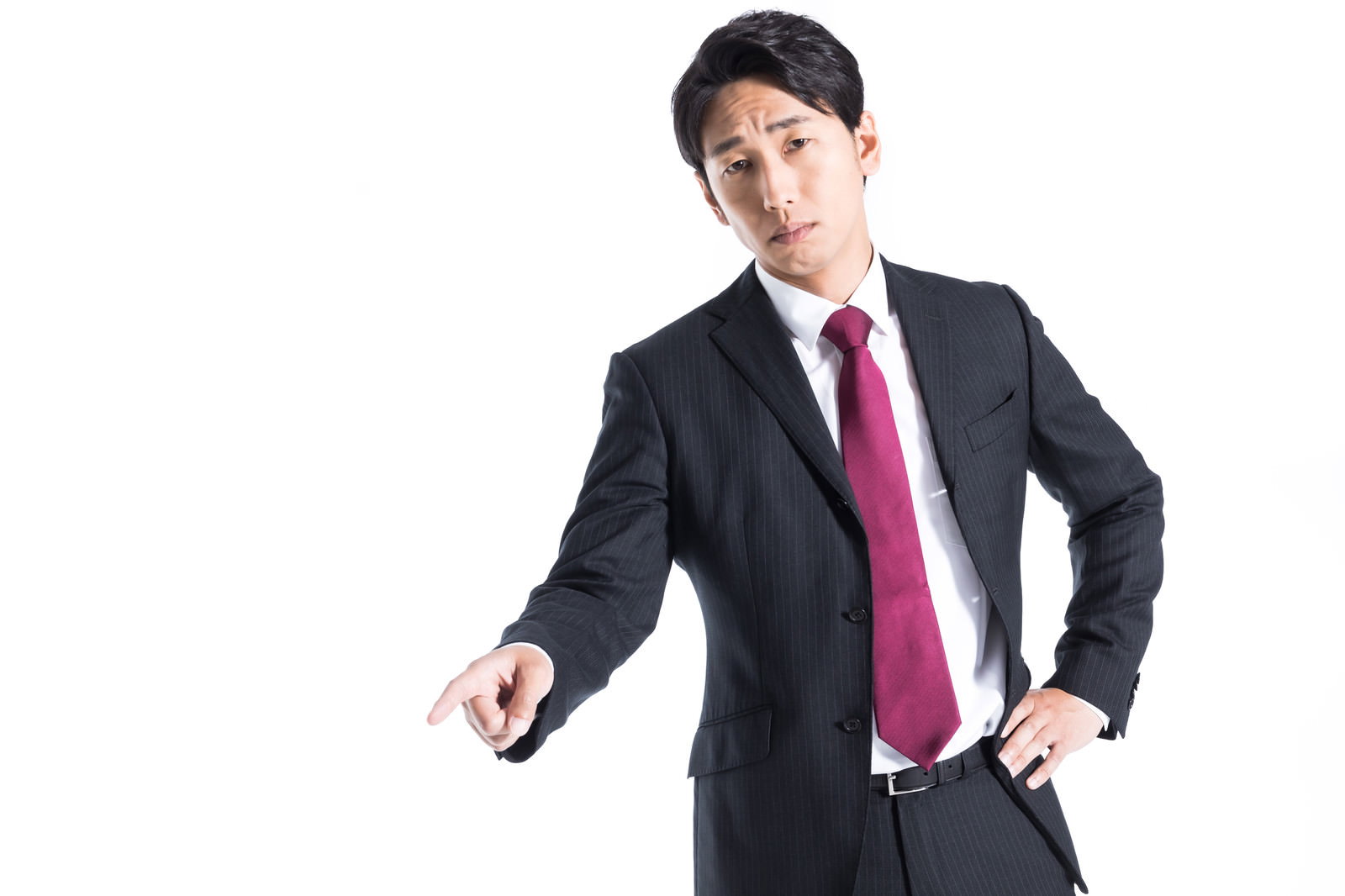 決め顔で指を差すスーツ姿の会社員男性［モデル：大川竜弥］
