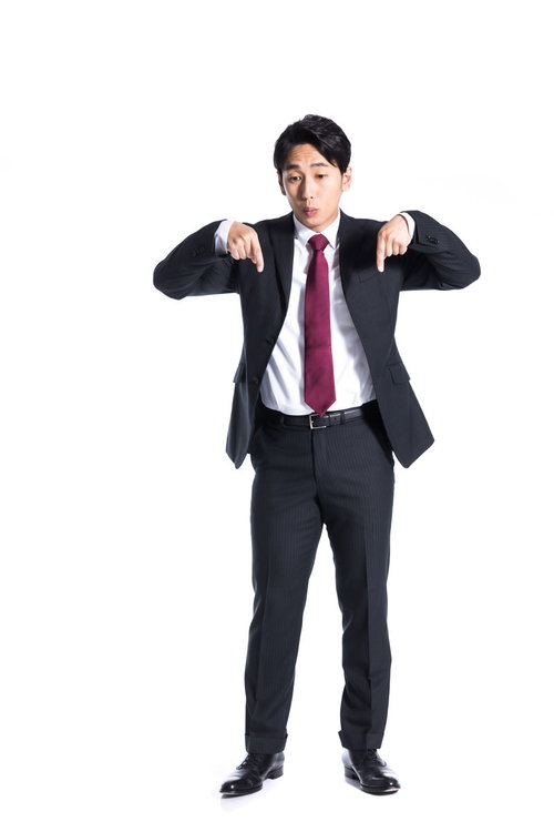 両手で足元のポイントを指差す紺色スーツの男性