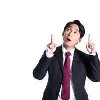 視線を上に集める驚いた表情のスーツ姿の男性の写真