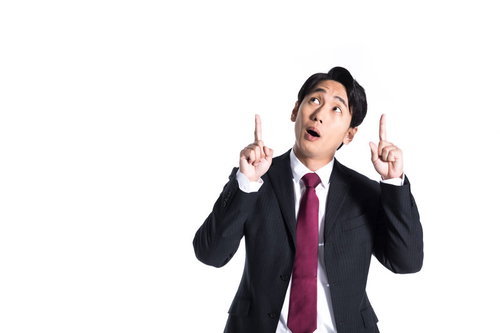 視線を上に集める驚いた表情のスーツ姿の男性