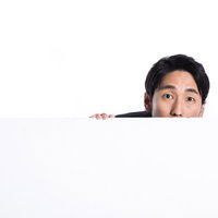 ホワイトボードから顔を出す進撃の会社員男性の写真