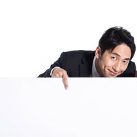 詳細はこちらからと白い看板の上から下を指さす販売員の写真