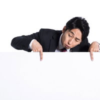 批判コメントを眺めながら困った表情で覗く男性の写真