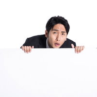 マジレスに驚きを隠せない白い看板の後ろの男性の写真