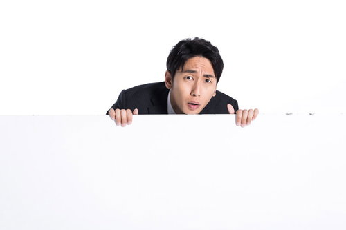 マジレスに驚きを隠せない白い看板の後ろの男性