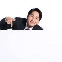 満面の笑みでスーツ姿の男性会社員が下を指さすの写真